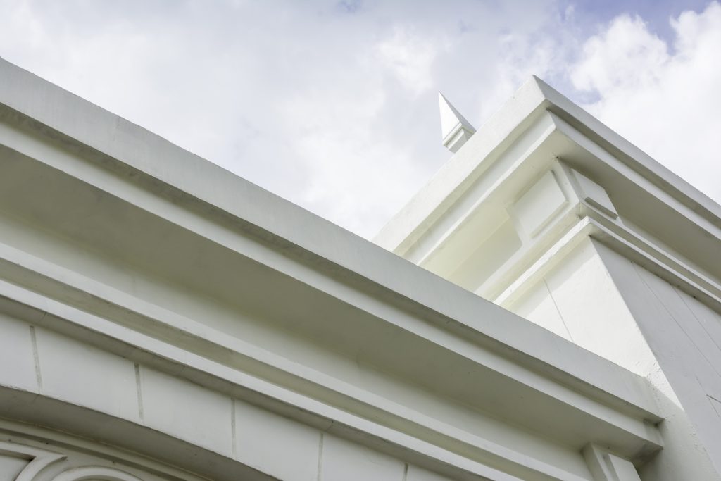 Parapet mouldings and quoins installed on a rendered facade